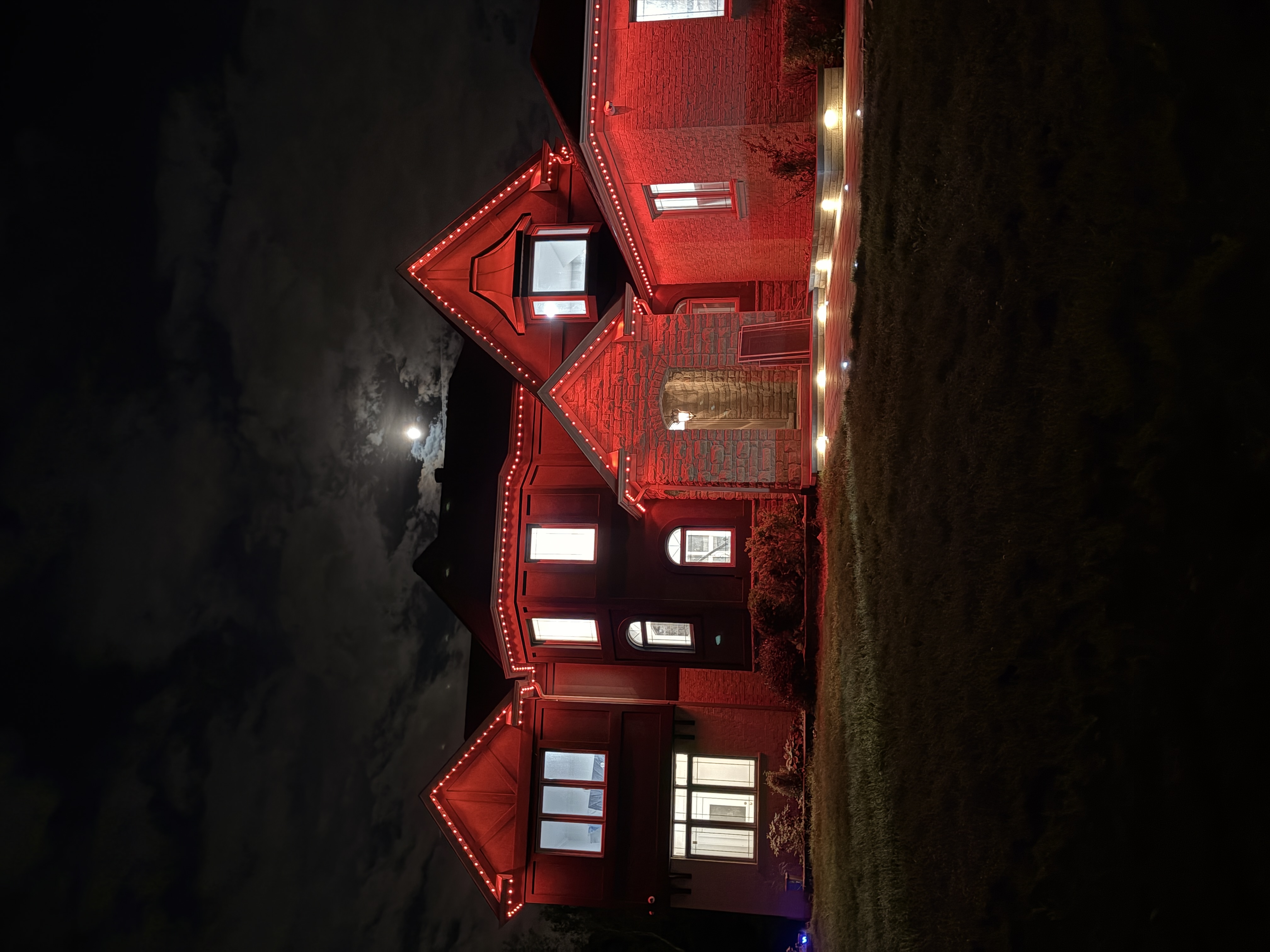 Red permanent lighting on a large home at night