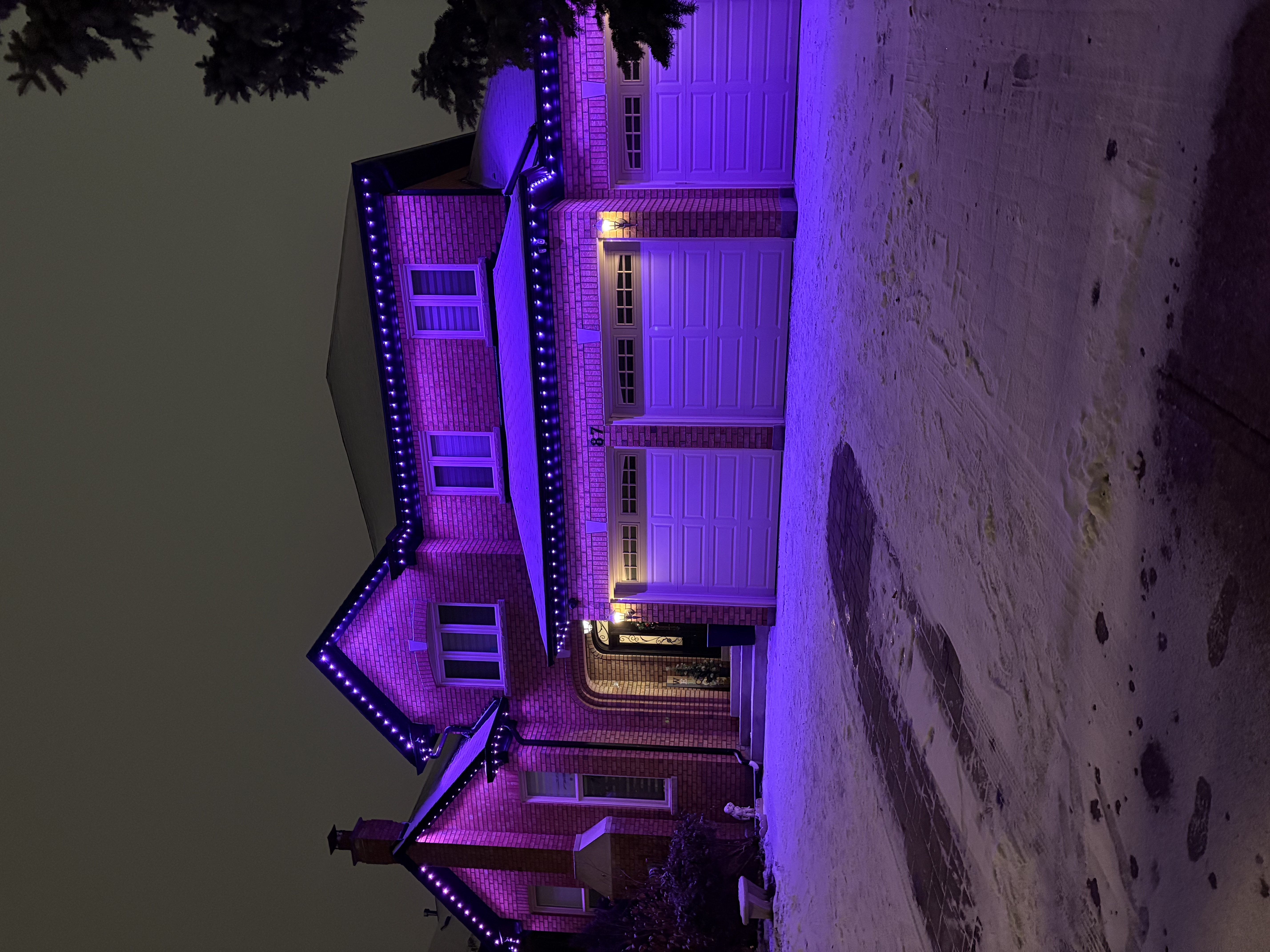 Purple permanent lighting on a brick home