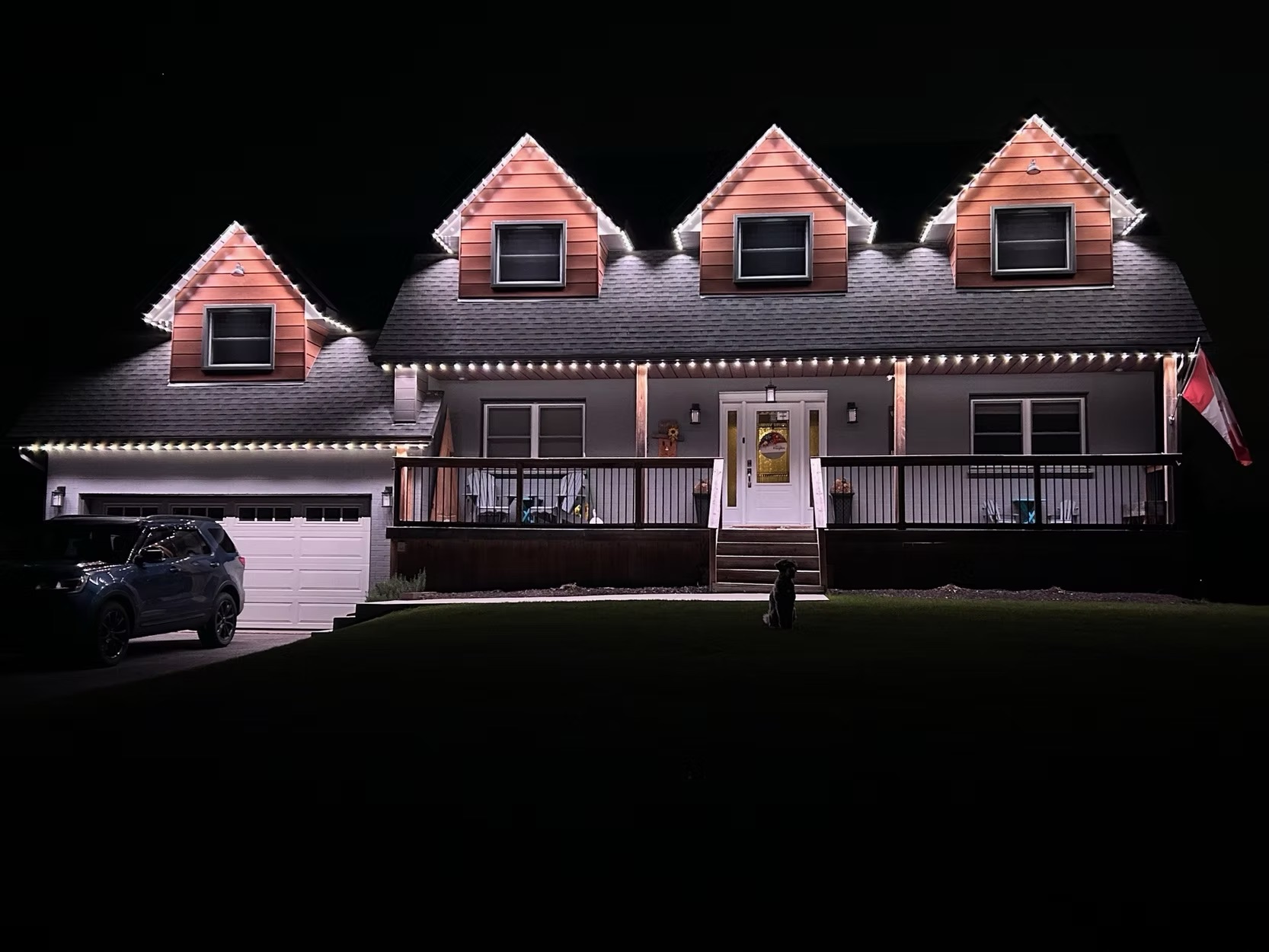 White permanent lighting outlining a traditional two-storey home at night