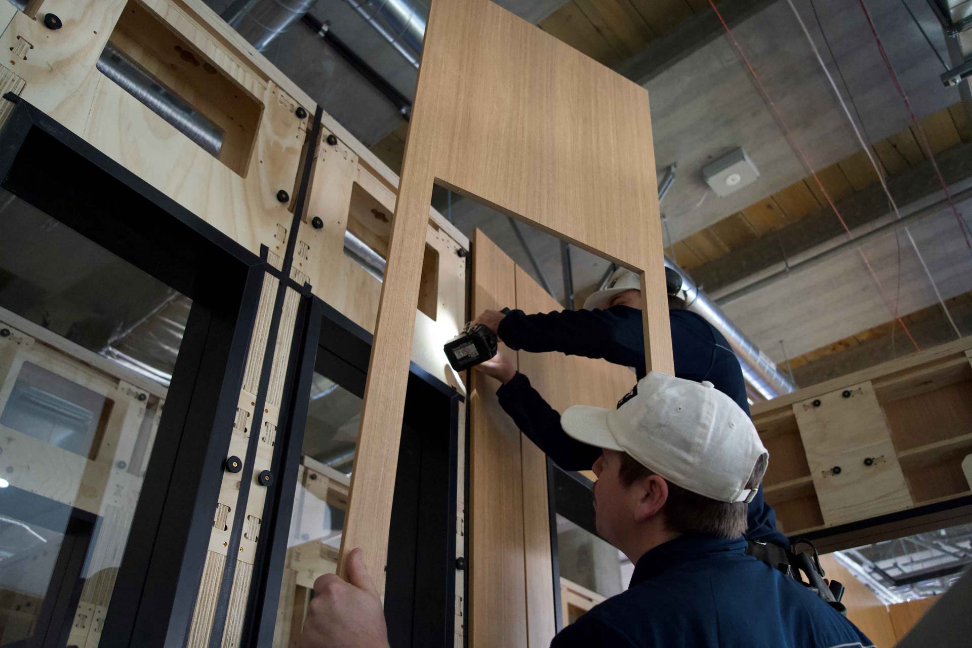Two builders applying a window a Tasmanian oak lining with XF010 clips lining systems on an XFrame window panel.
