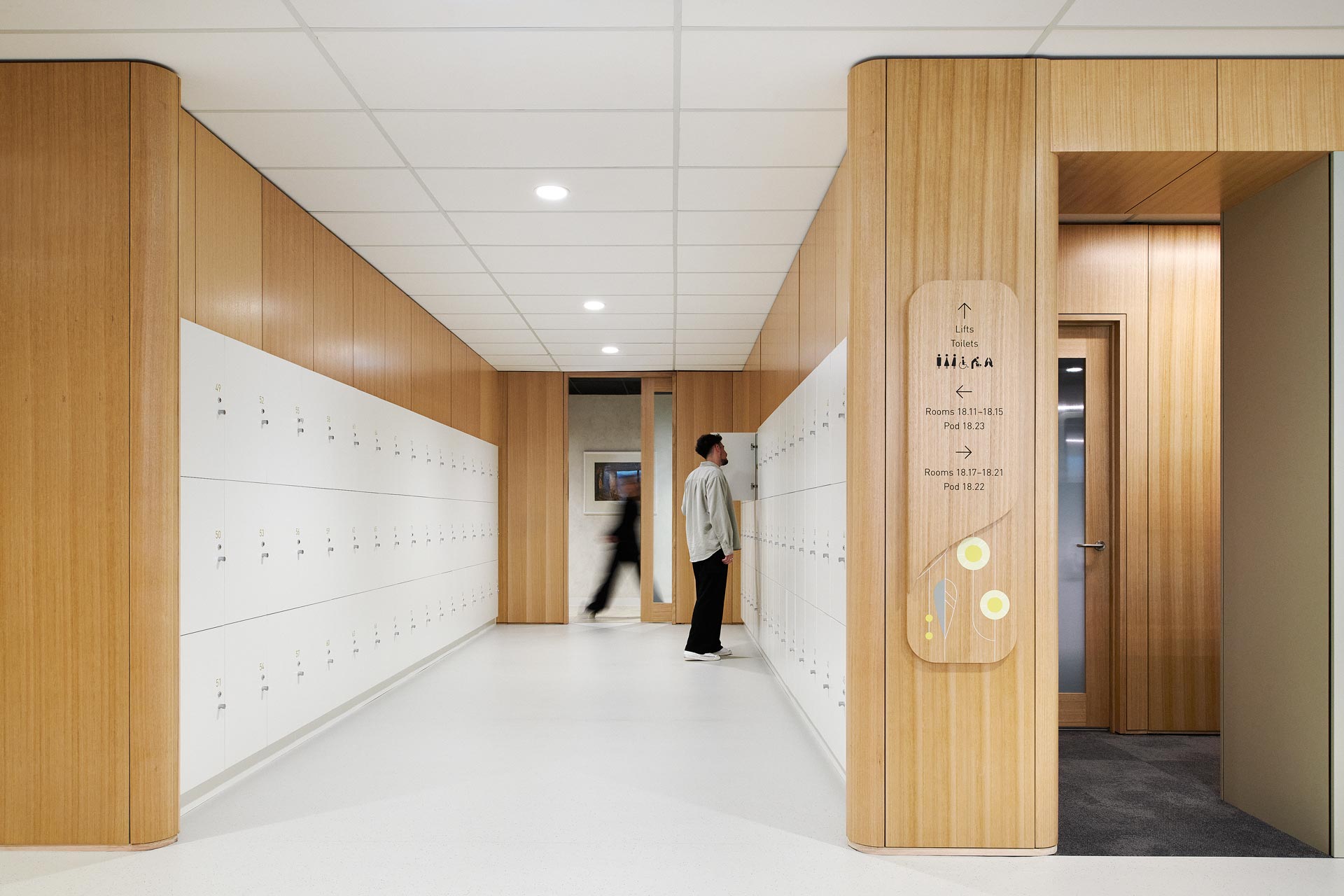 A hall way in the ANZ Pirie St Office, with white lockers and another door leading to another corridor with more rooms.