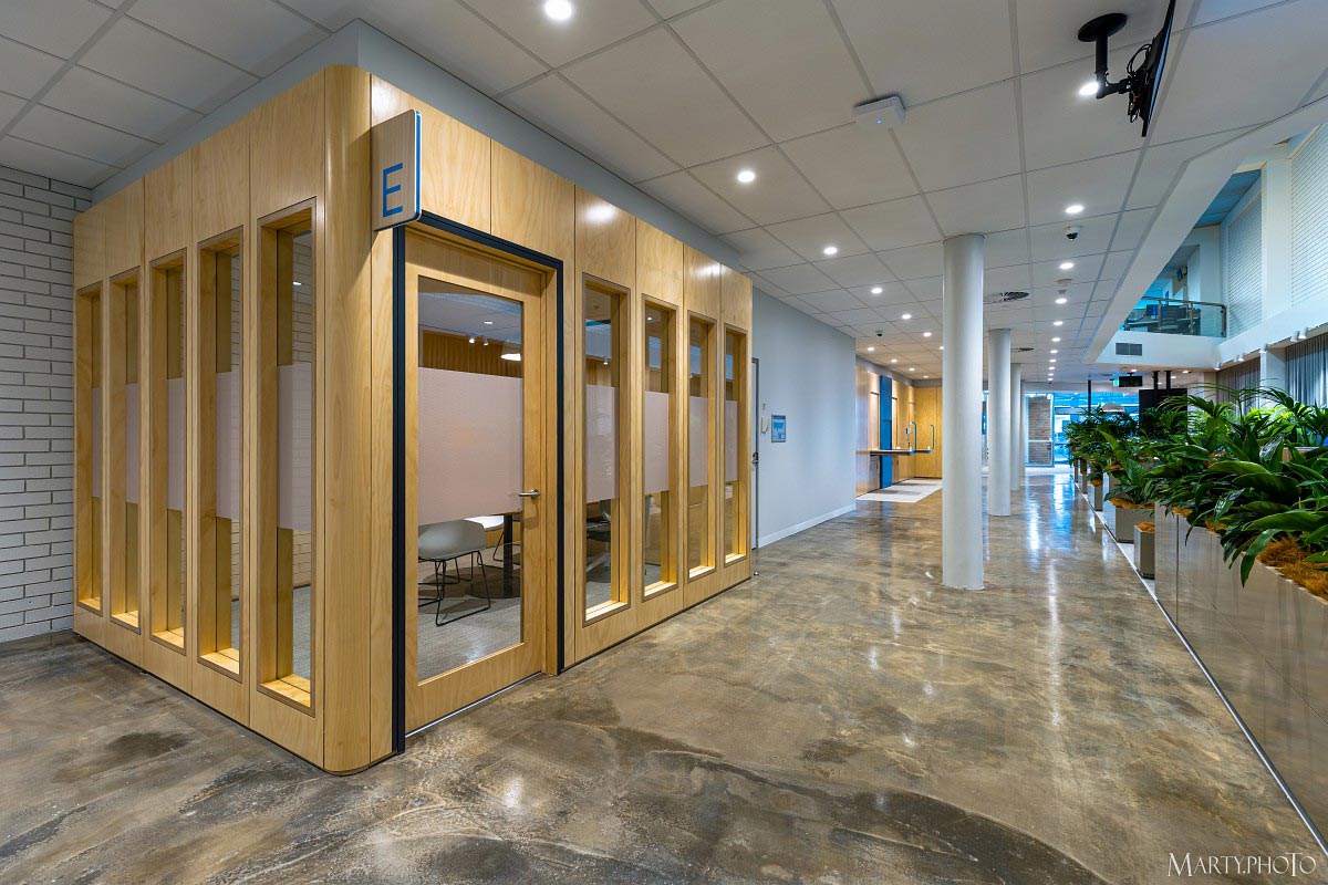 A meeting room in ANZ Lismore on the left with a line of planters on the right.