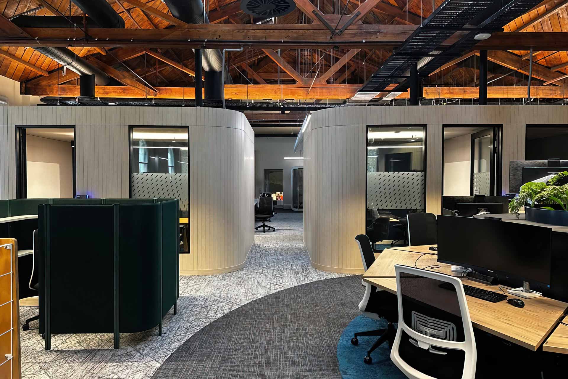 Two XFrame meeting rooms in the Meridian Energy office, surrounded by desks with computers and office chairs. Assembled and up and finished.