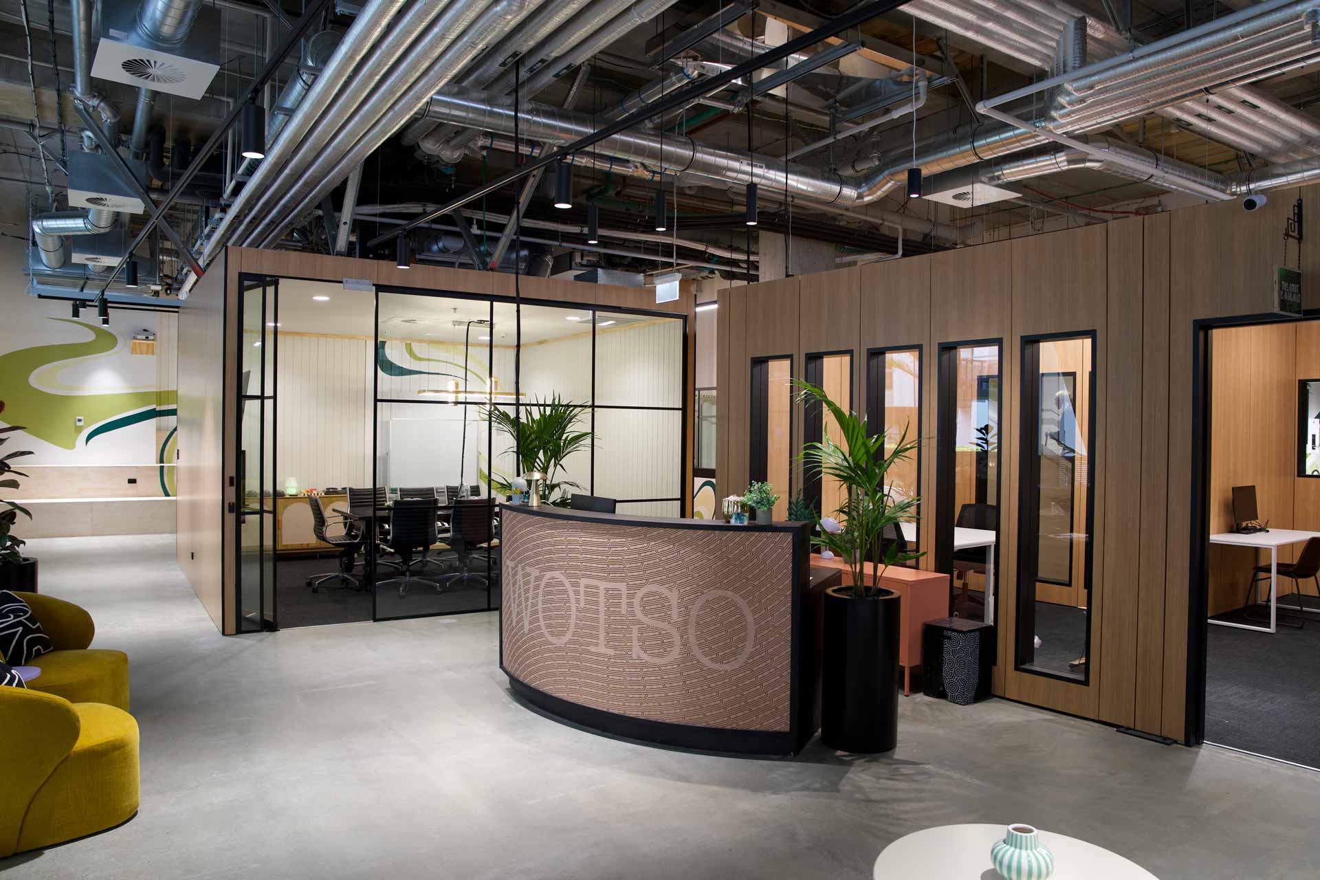 WOTSO Te Toangaroa Reception area, with a reception desk, and two meeting rooms behind it. The left board room with full glass front windows and on the right meeting rooms made out of XFrame.