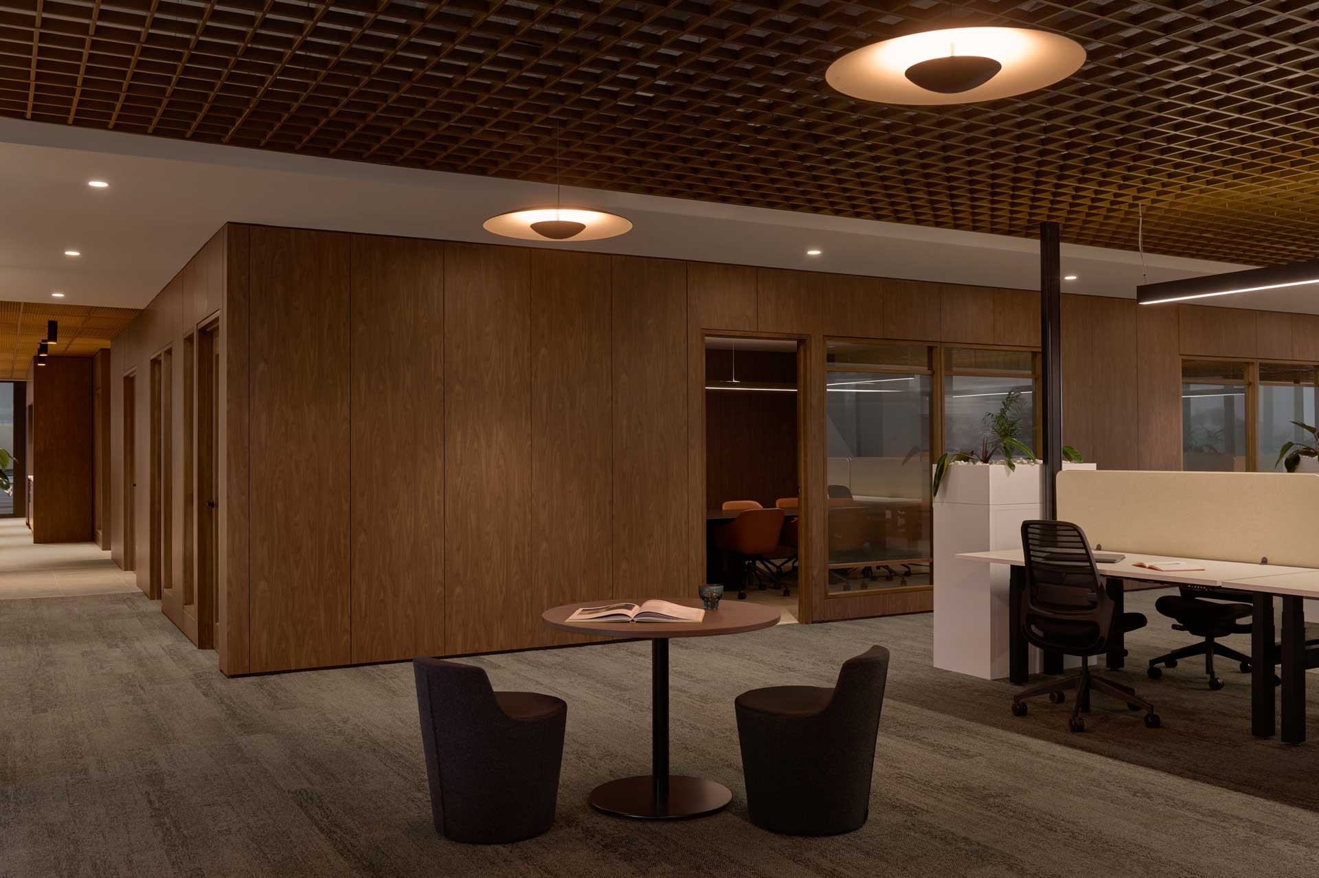 A XFrame room in Westralia Square 2, with Walnut laminate linings. A little coffee table with two plum chairs, and a line of desks on the right.