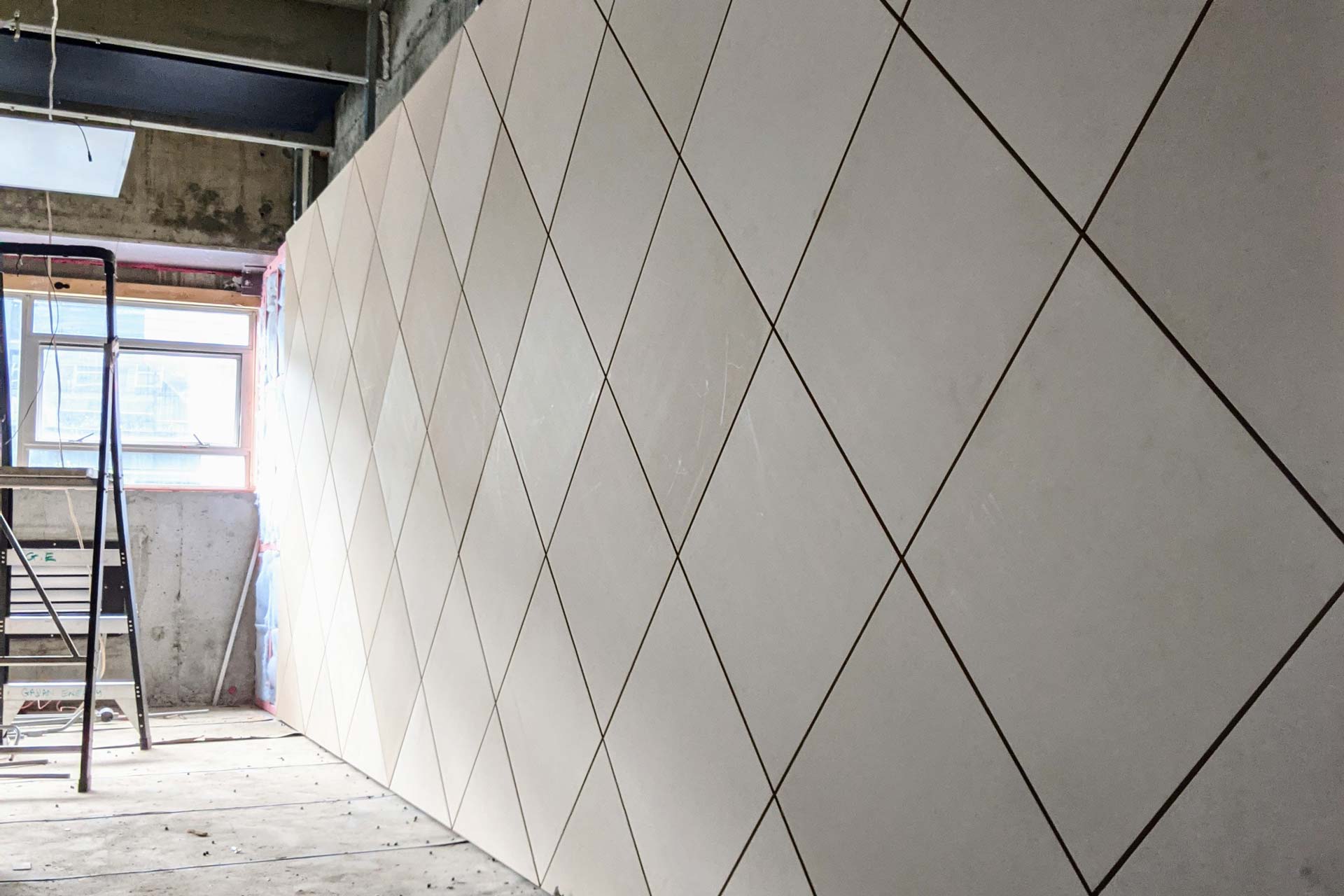 A long line of XFrame panels with the diamond steel linings dividing a large room.