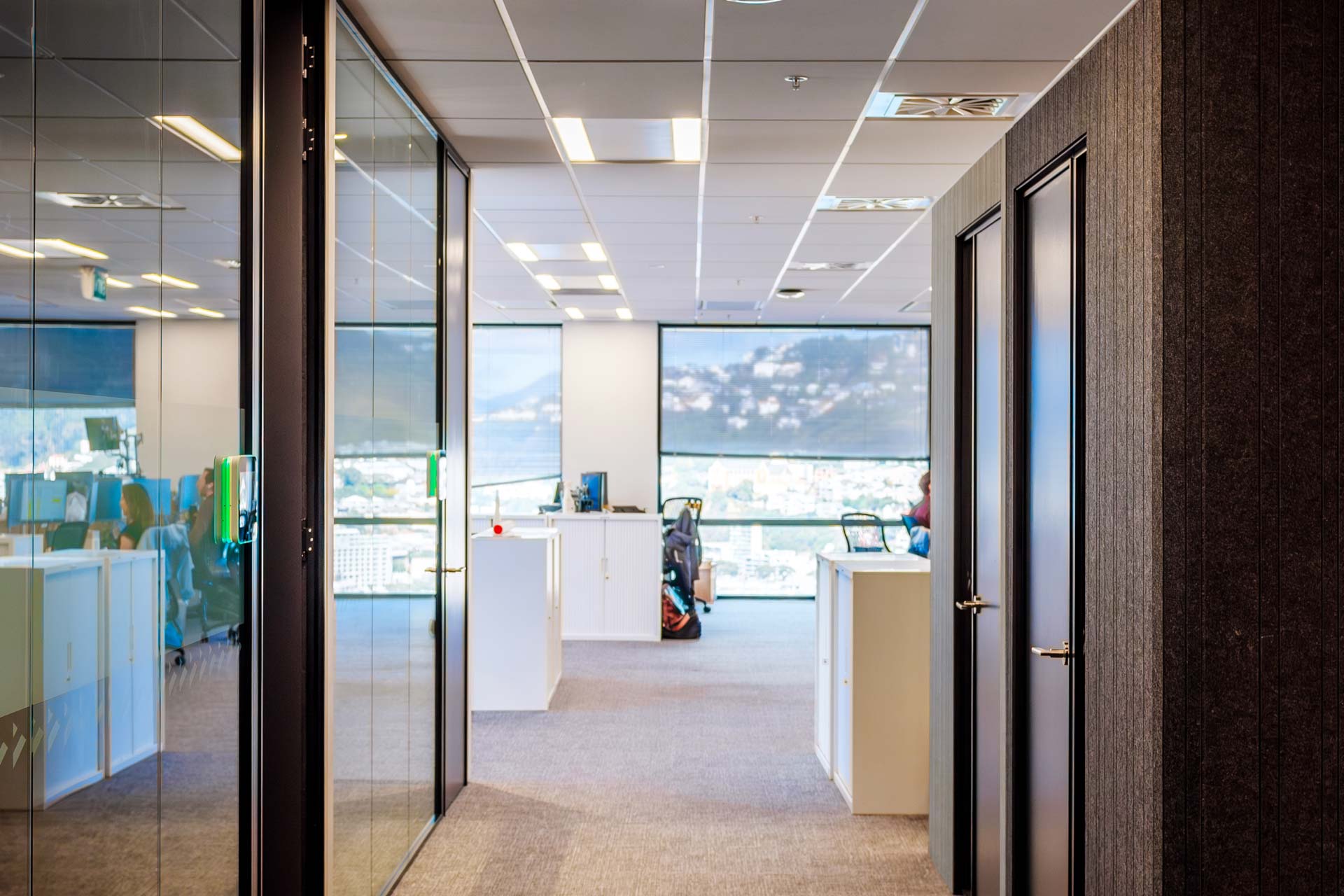 A hallway looking at four meeting rooms, two on the left and the two XFrame Booster meeting rooms on the right.
