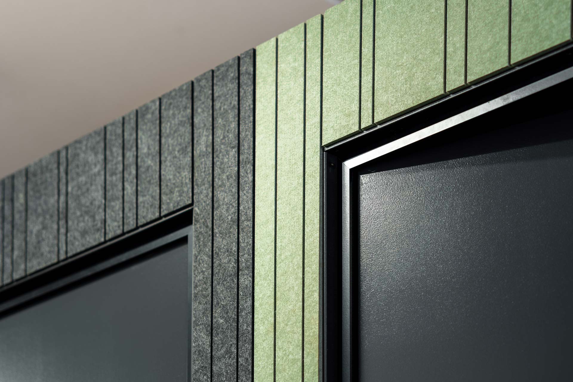 Close up of the exterior groove pet linings of two booster meeting rooms, with the top corners of black doors.