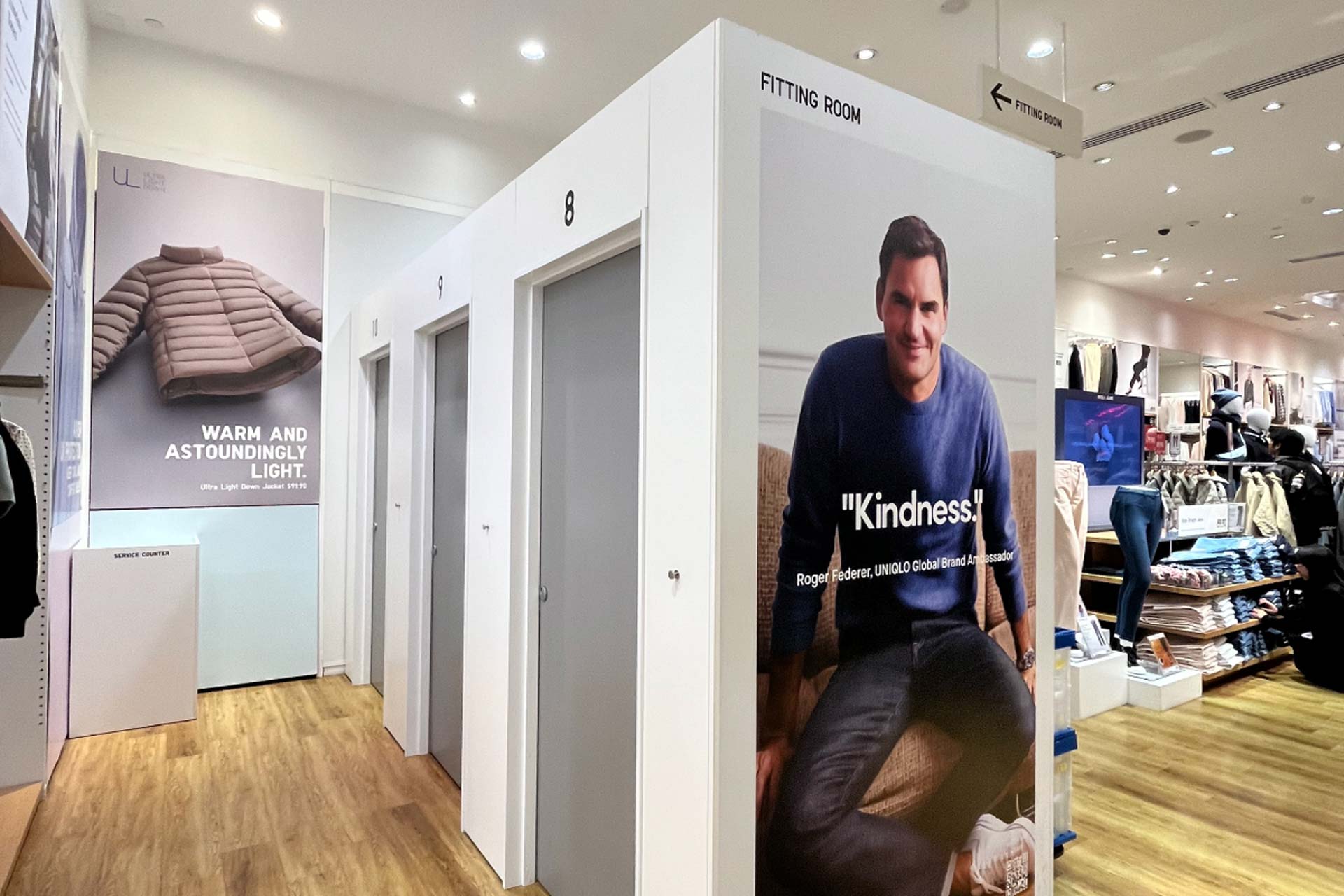 Finished and lined XFrame Uniqlo changing rooms with grey doors and a picture of Roger Federer on the side.
