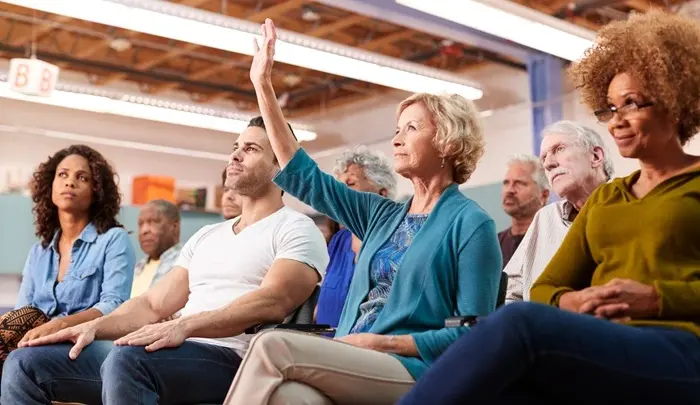 Homeowners attending a community association meeting, raising questions and participating in decisions—showcasing how ManageCasa supports transparent HOA governance