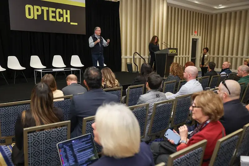 Speaker presenting on stage at the OPTECH 2025 conference in Las Vegas, addressing property management and technology professionals.