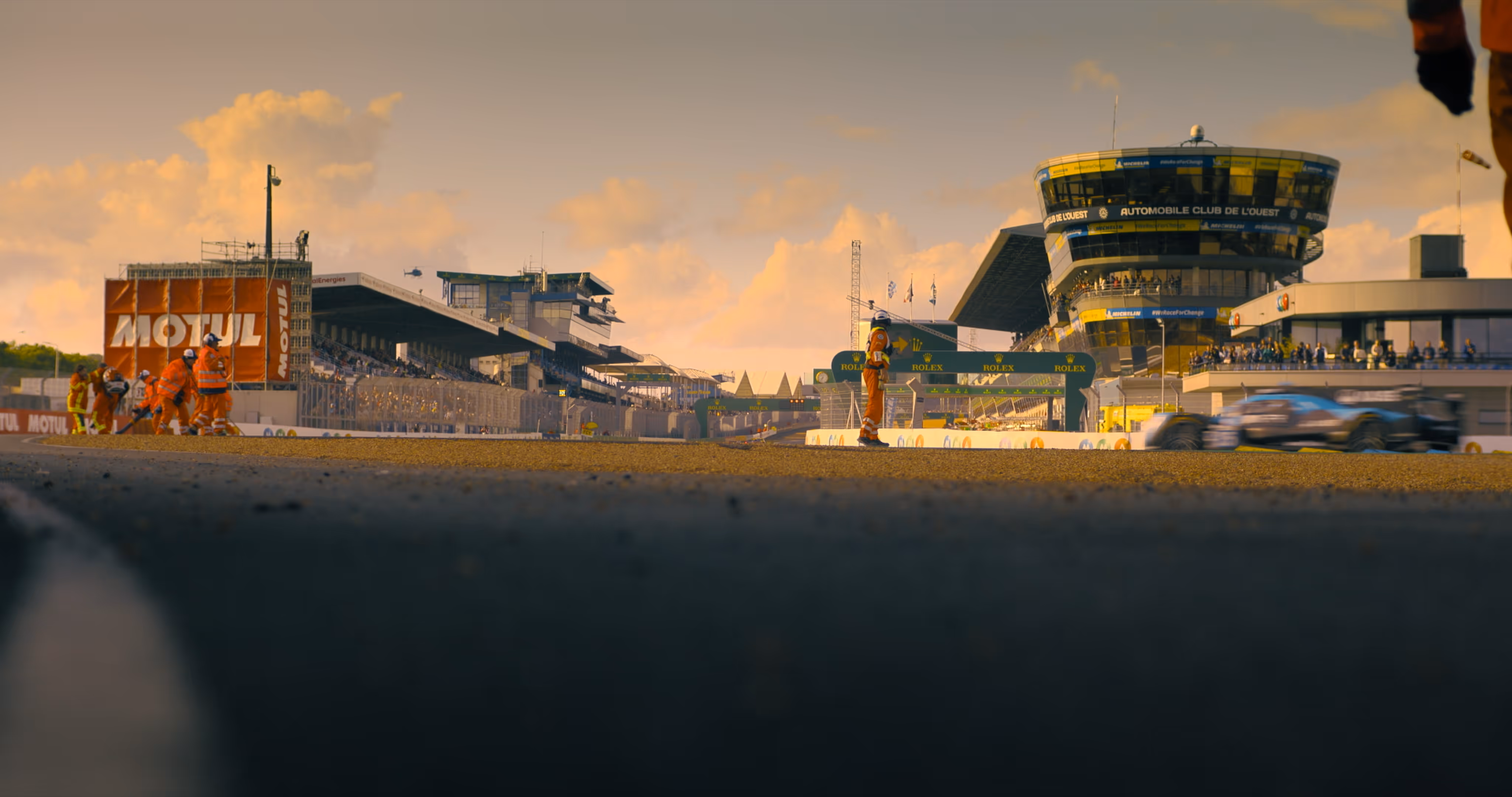 Race track scene at sunset with marshals in orange suits, captured for 2DIE4 Film Documentary.