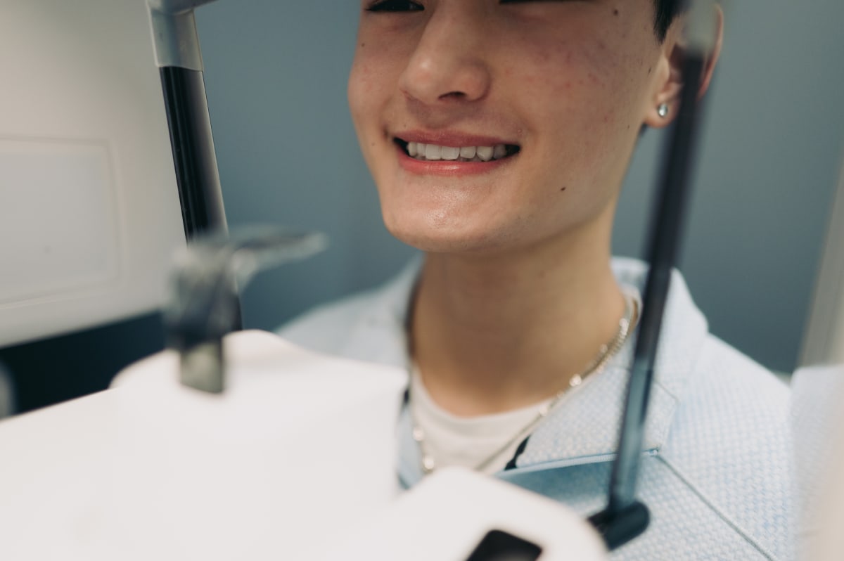 Young patient smiling in dental chair with nitrous oxide mask during treatment