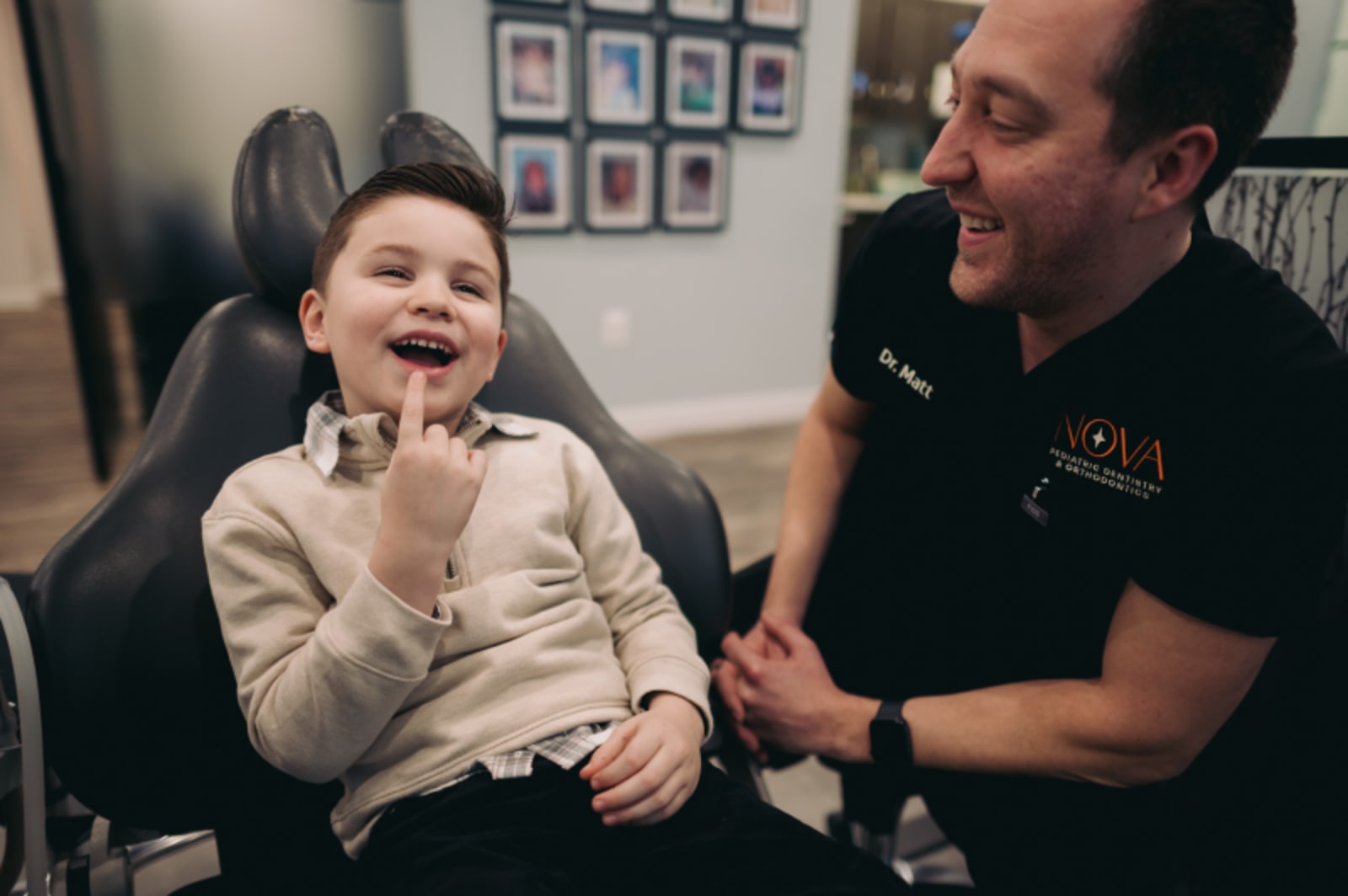 Pediatric dentist showing young child dental model during consultation