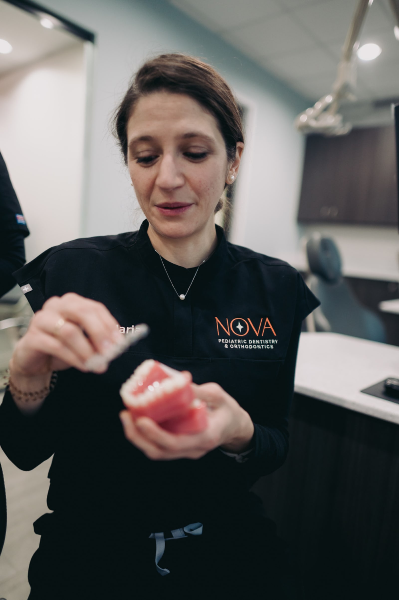 Dental professional demonstrating composite filling technique to young child