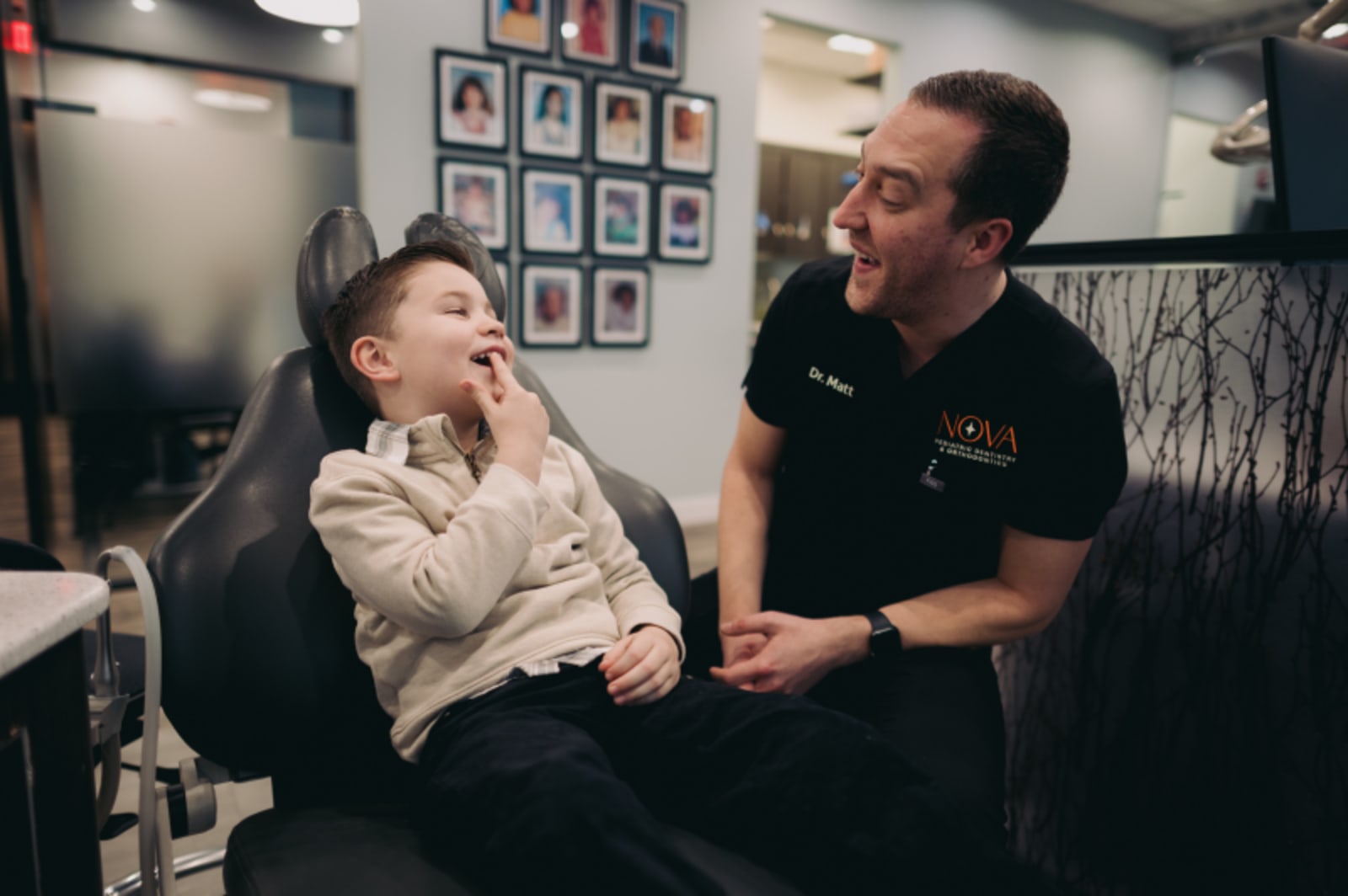 Pediatric dentist examining a young child in the treatment chair during appointment