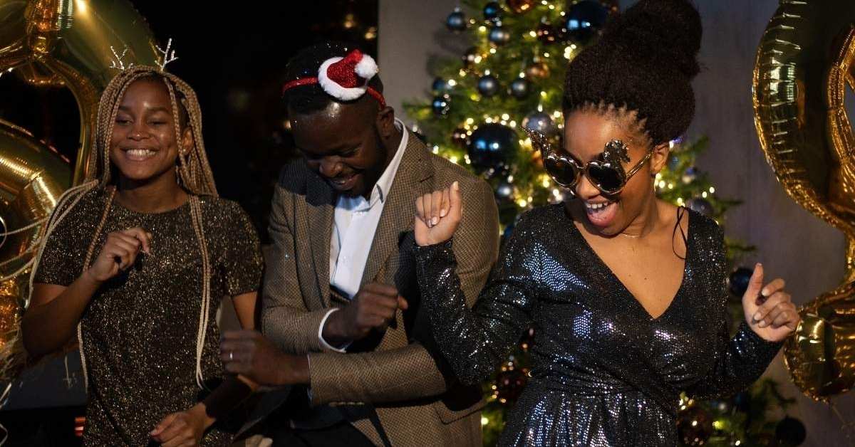 Three people dancing joyfully at a festive Christmas party.