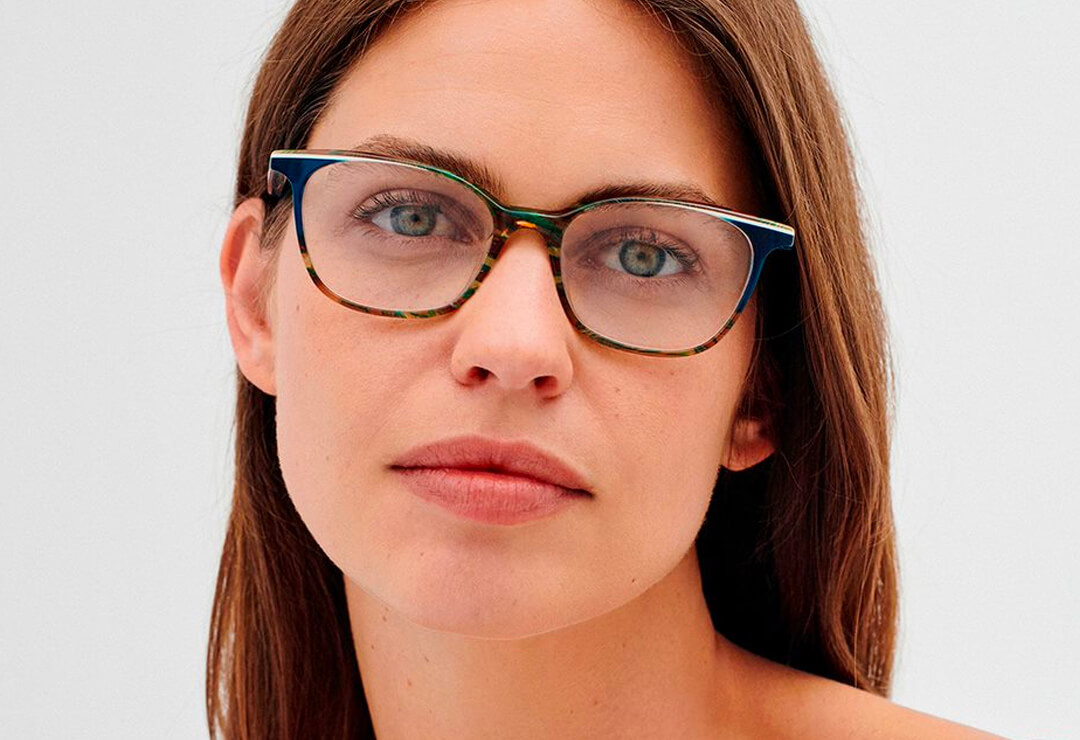 Woman wearing dark slim rectangular glasses, facing forward.