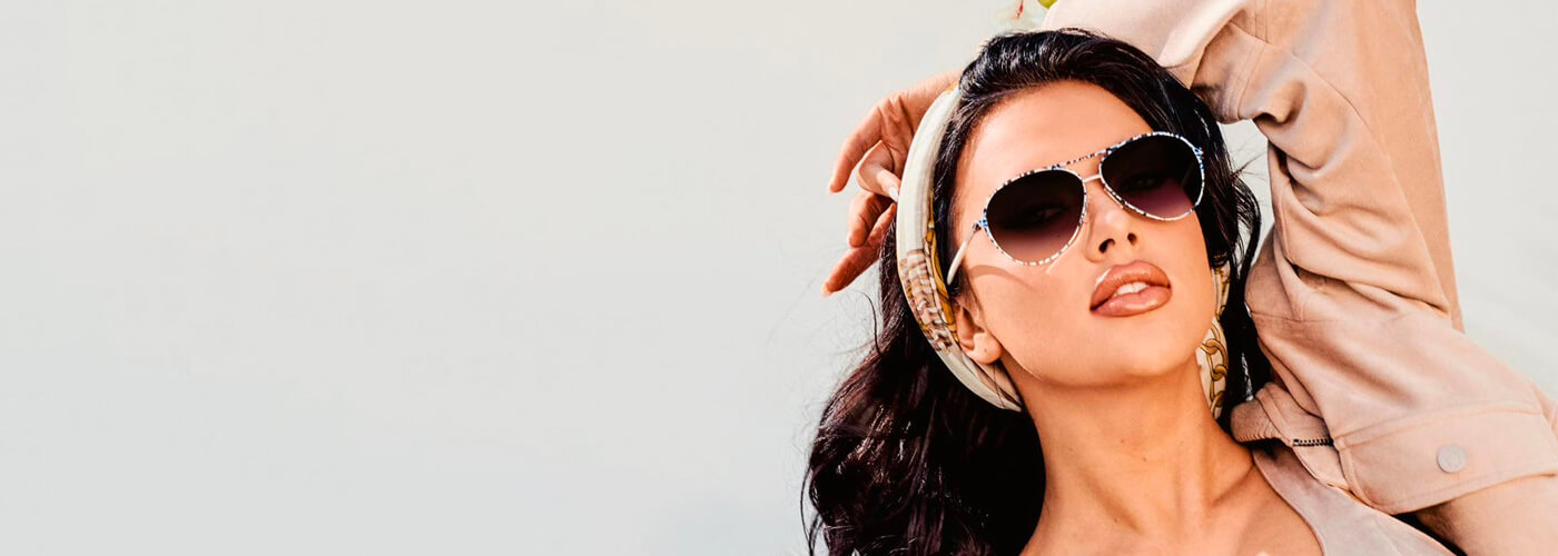Woman wearing embellished aviator sunglasses with a silk headband.