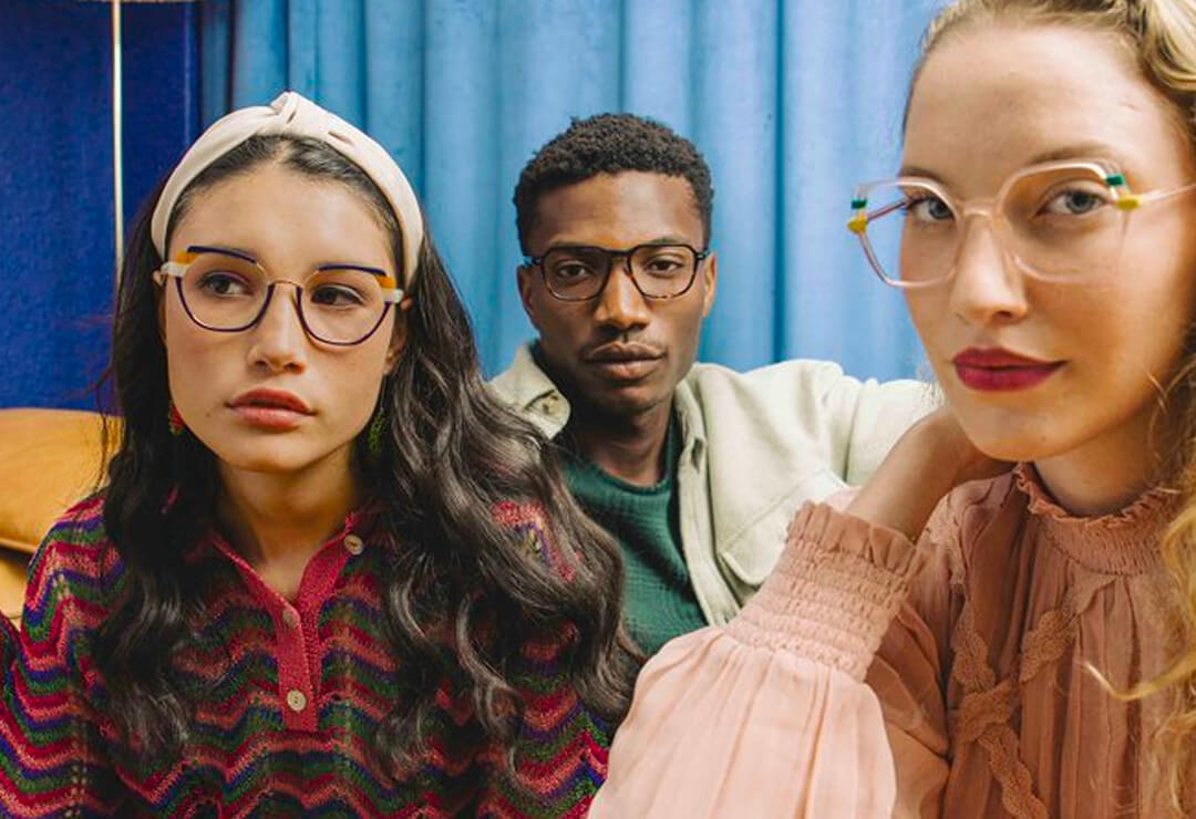 Group of three people wearing colourful Woodys glasses frames.