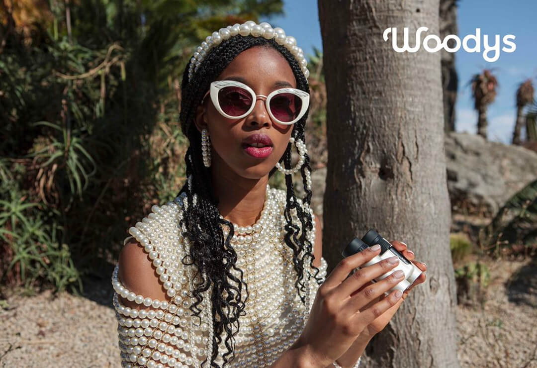Woman wearing white round Woodys sunglasses outdoors.