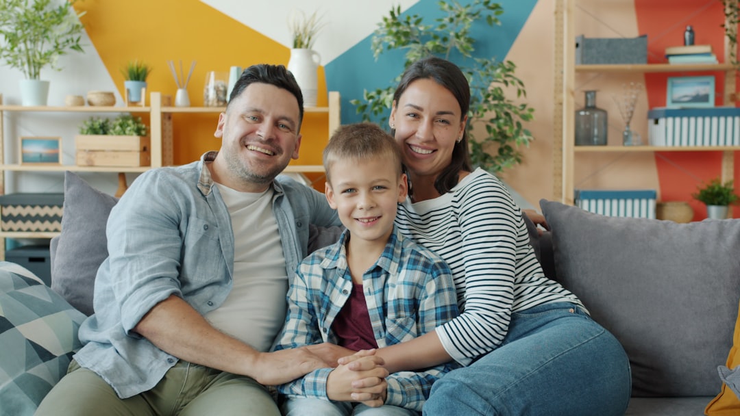 a happy family sitting on a couch in a living room breathing clean indoor air