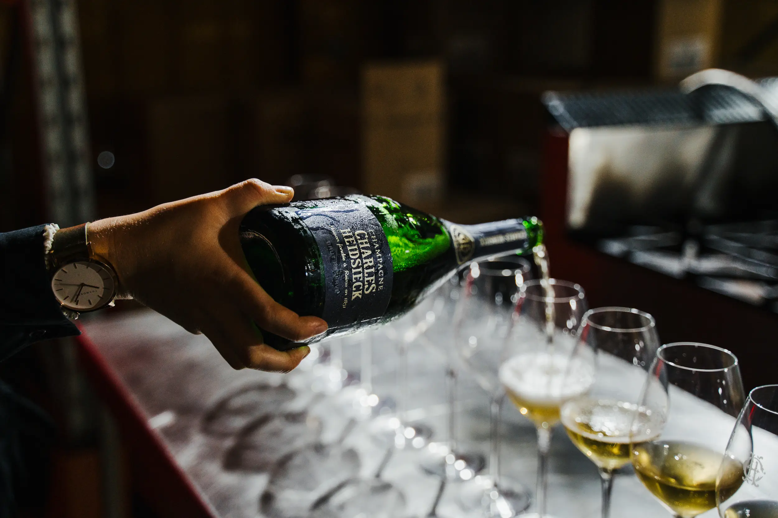 A person pouring wine into a wine glass.