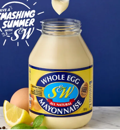 A bottle of mayonnaise sitting next to a lemon slice.