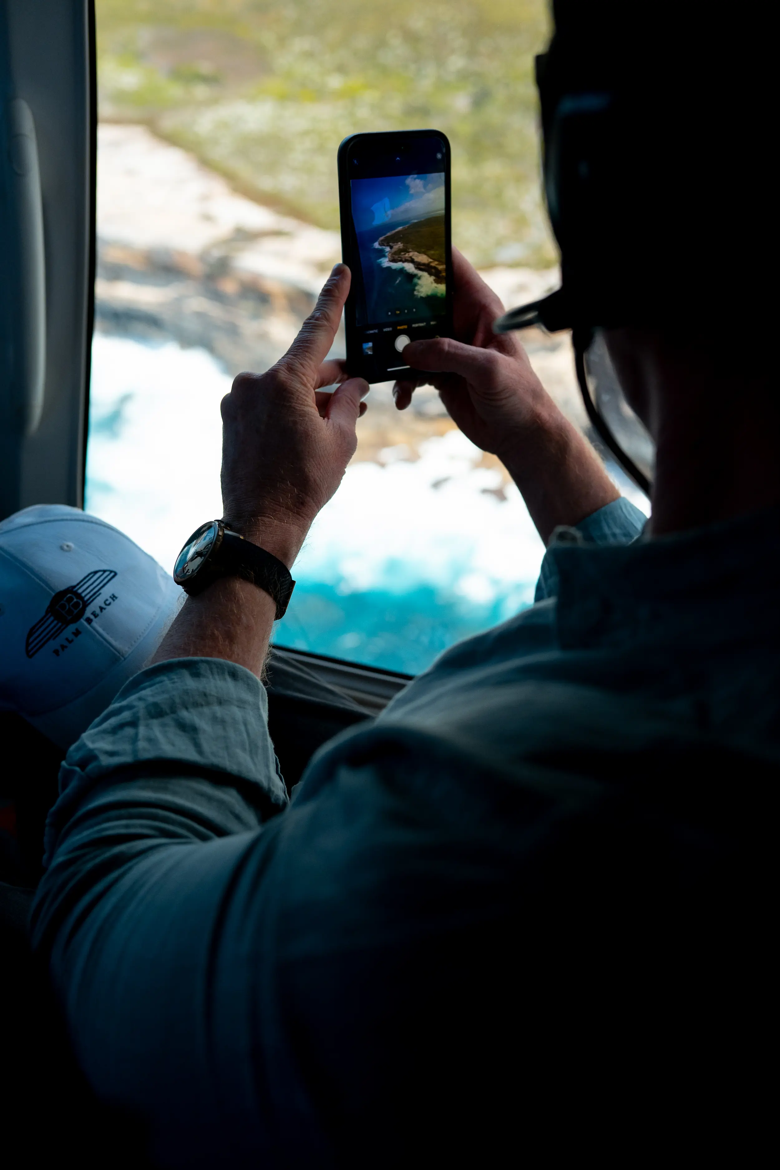 A man sitting in a car looking at his cell phone.