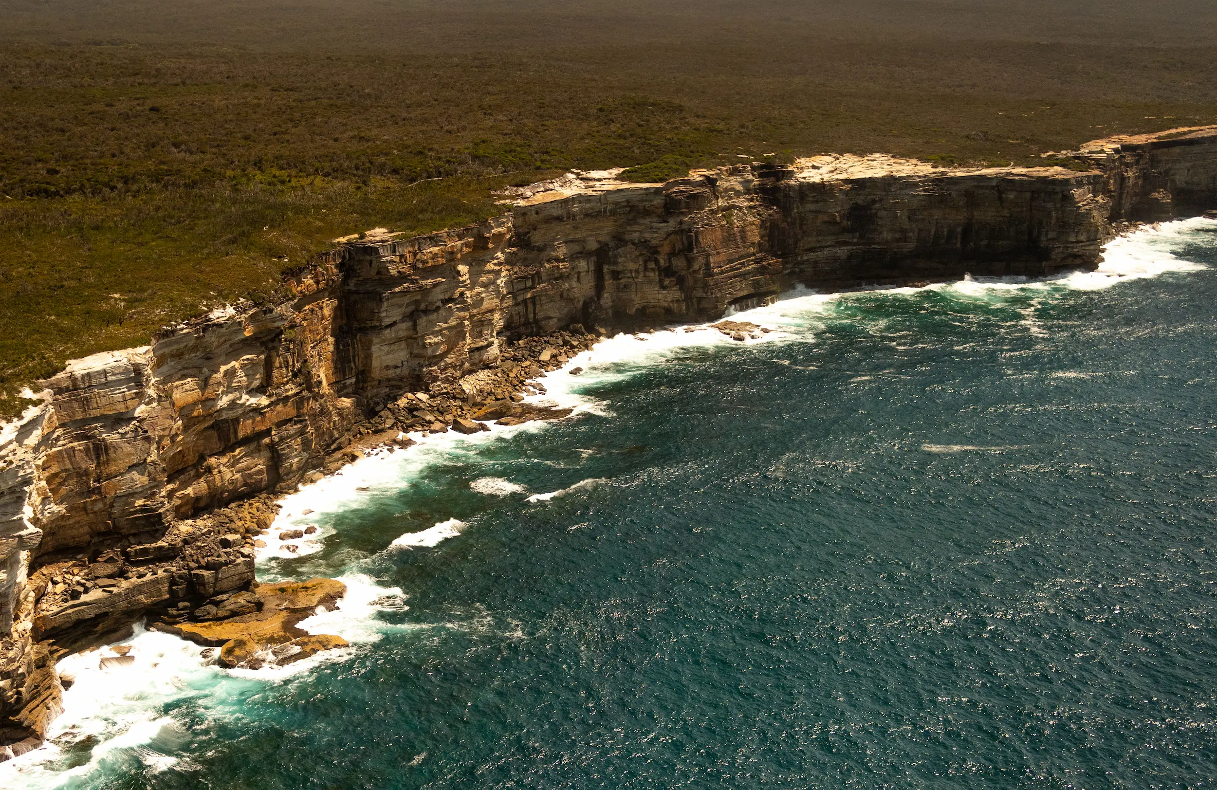 An aerial view of the ocean and cliffs.