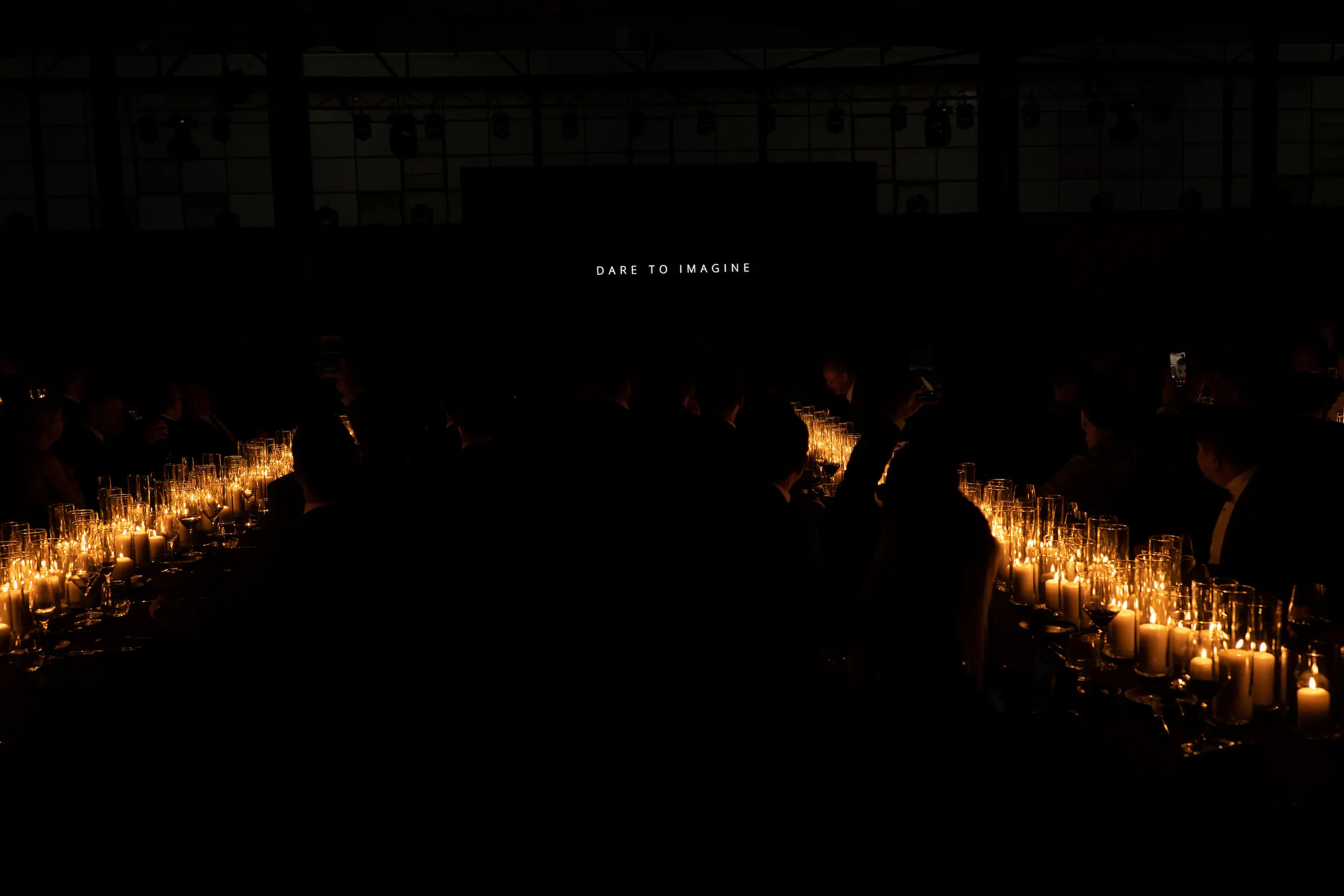 A group of people sitting around a table with many lit candles.