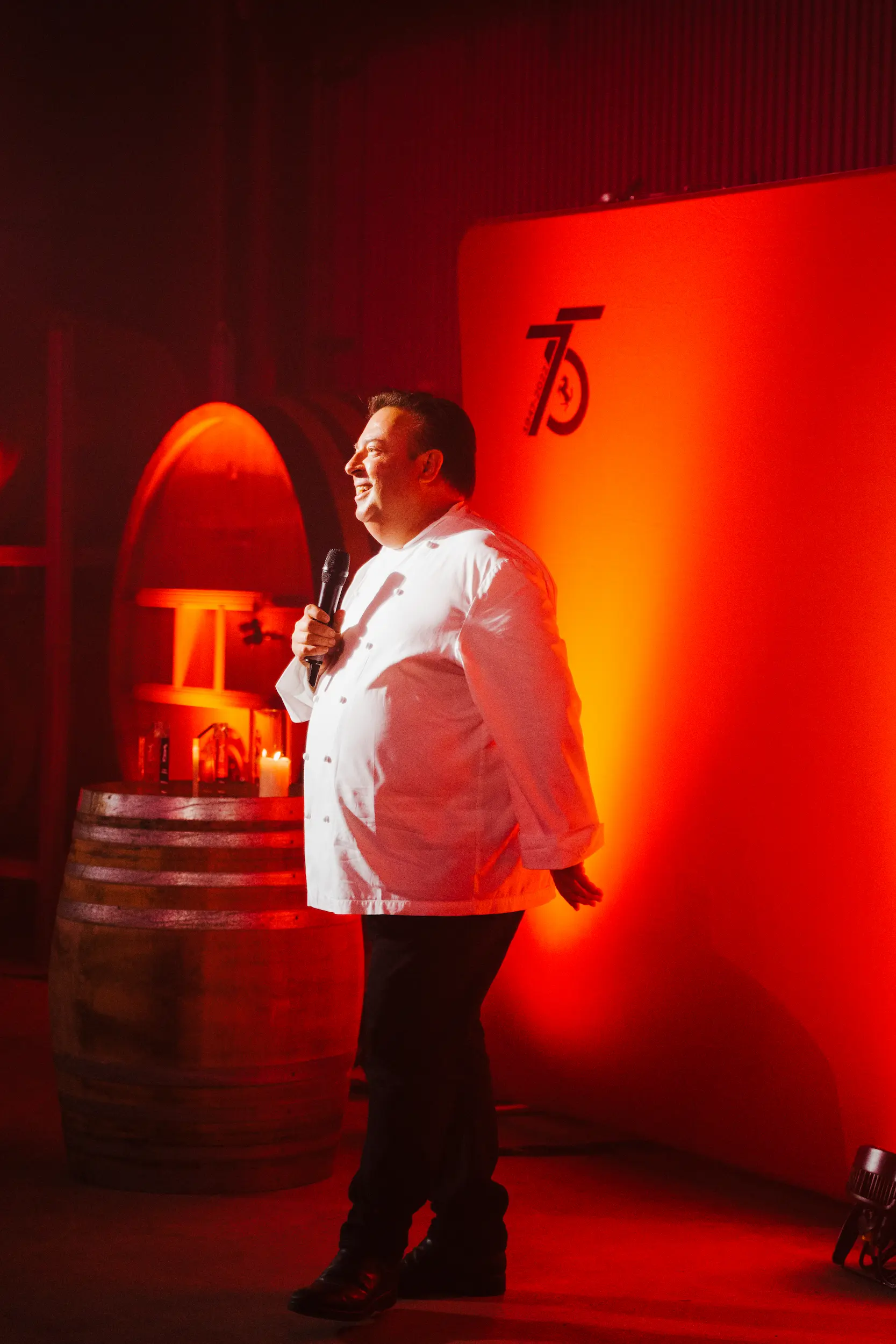 A man standing in front of a barrel of wine.