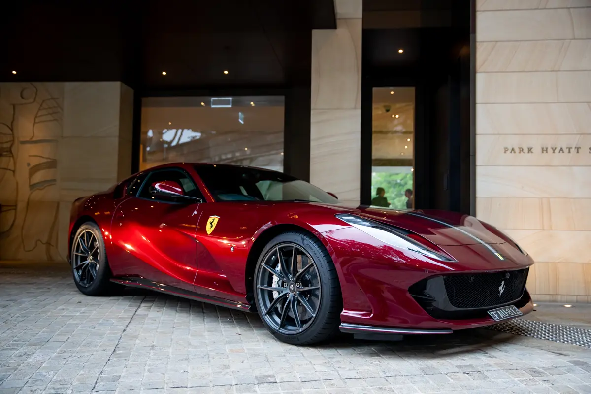 A red sports car parked in front of a building.