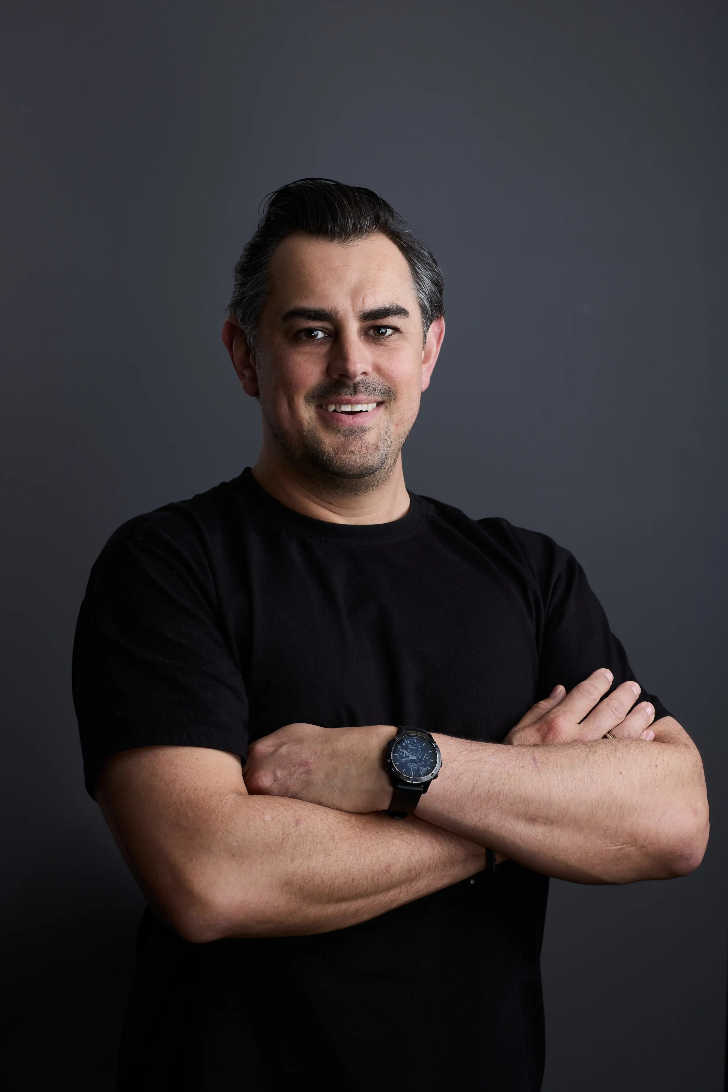 A man in a black shirt with his arms crossed.