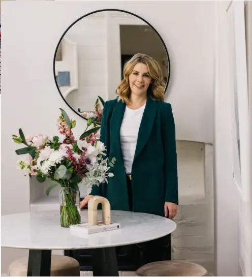 A woman standing in front of a table with flowers.
