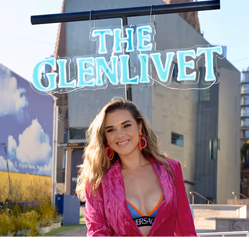 A woman in a pink top is playing a dj set.
