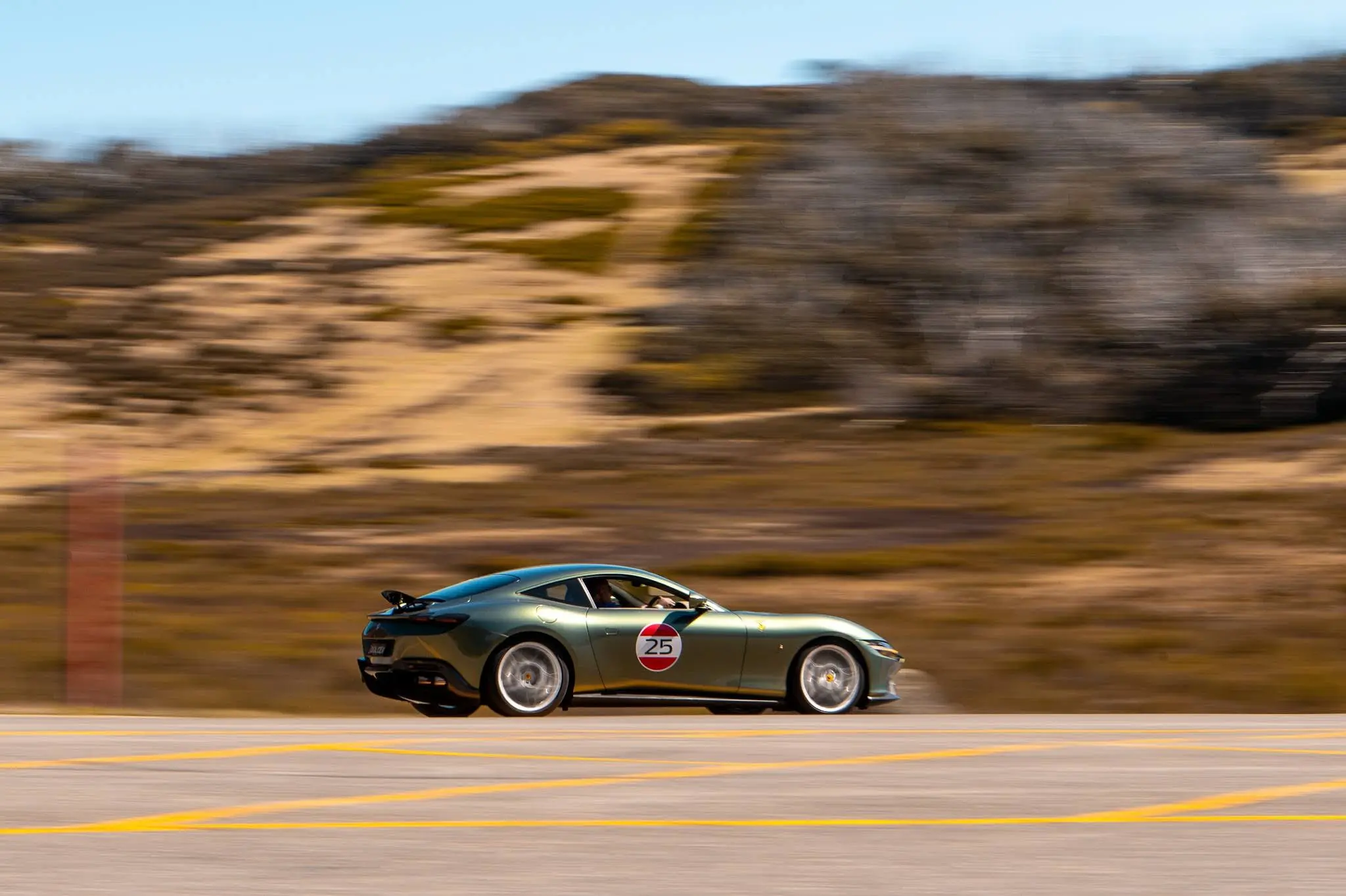 A green sports car driving down a road.