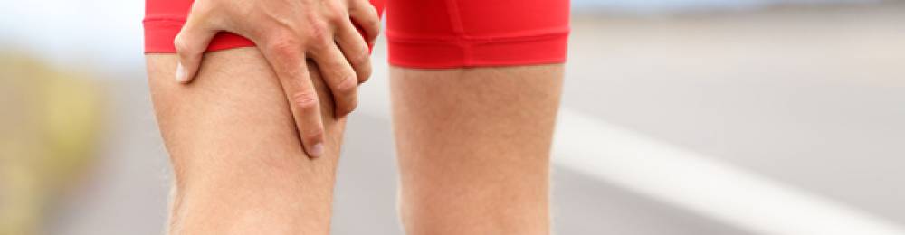 A sports physiotherapist assessing a thigh muscle contusion, representing severe bruising treatment for PhysioLocal.