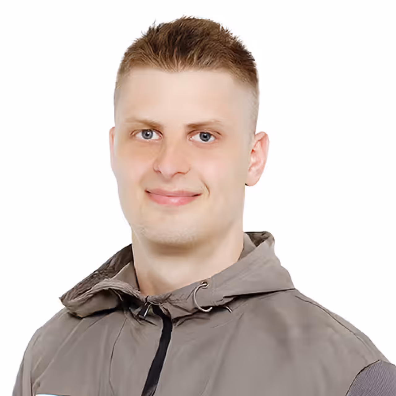 Smiling young man with short light brown hair wearing a gray hooded jacket against a white background.