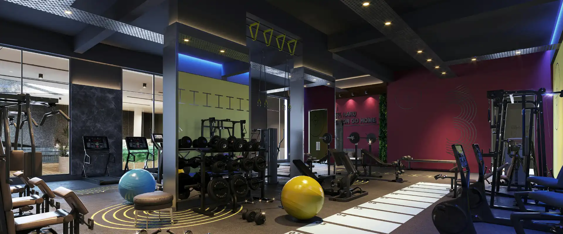 Modern gym interior with various exercise equipment, dumbbells, fitness balls, and motivational wall text.