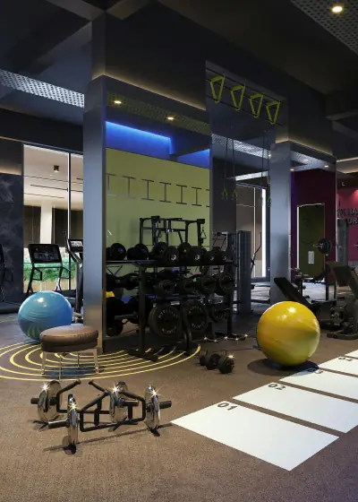 Modern gym interior with dumbbells, exercise balls, weight racks, and workout equipment.