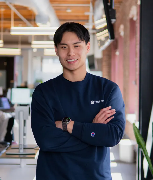Wayne Zhou, GM at Paraform and Concord Visa O-1A client, standing with arms crossed in an office