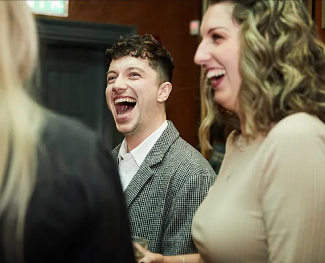 People with MS at an event laughing together