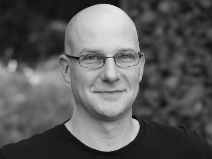 Black and white portrait of Jan Amann smiling