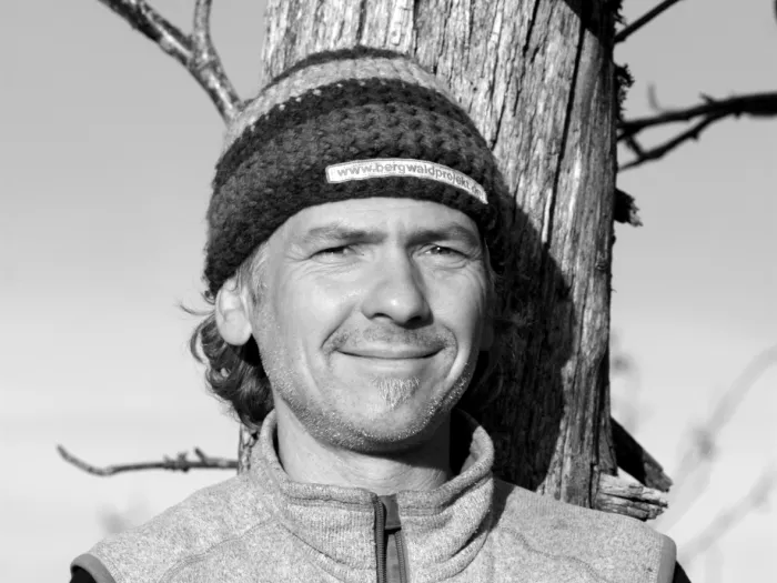 Black and white portrait of Stephen Wehner, wearing a beanie and smiling.