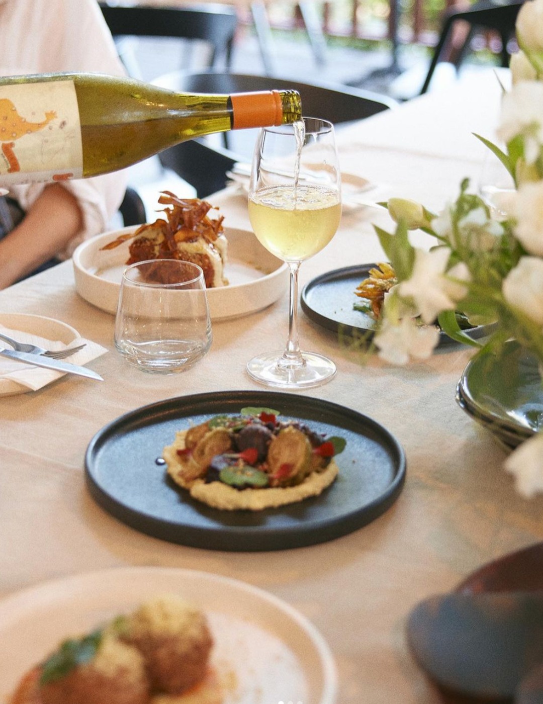 Server carrying seasonal plant-based bowls at Greenhouse Canteen