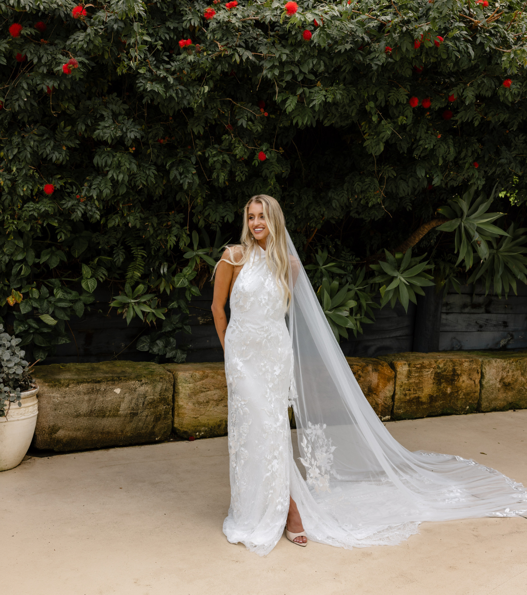 Bride in white lace gown with cathedral veil standing in the garden at 268 Estate, Tallebudgera Valley