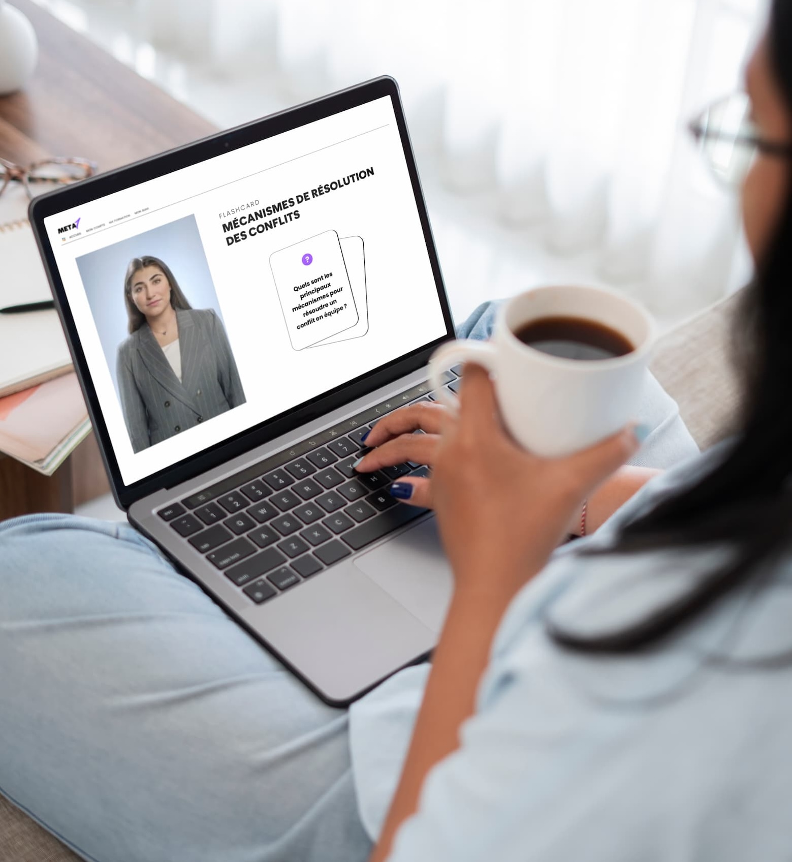 Personne tenant une tasse de café et utilisant un ordinateur portable affichant une page de flashcards sur les mécanismes de résolution des conflits.