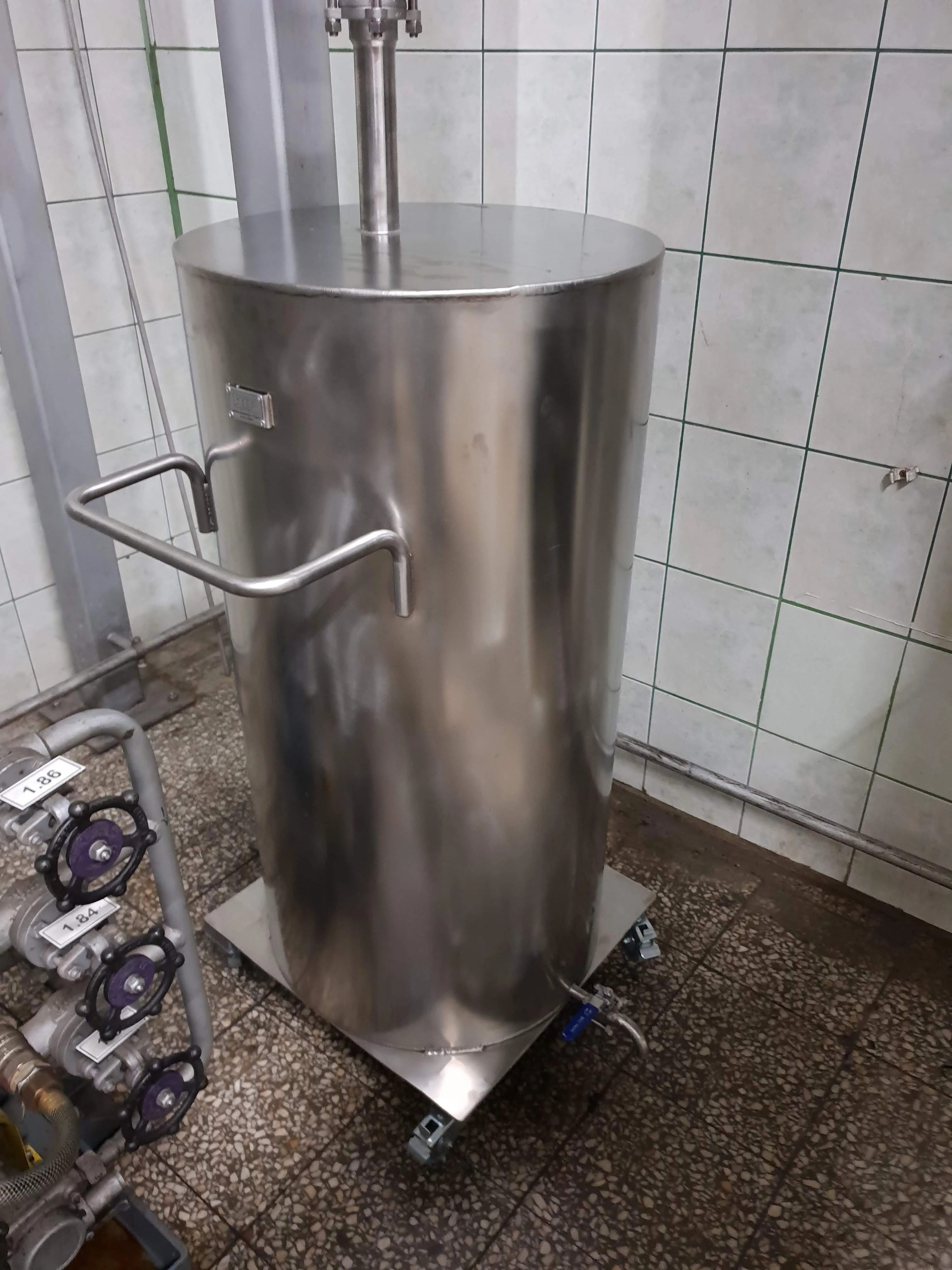 Grupa mężczyzn siedzących przy długim stole nakrytym białym obrusem w eleganckim wnętrzu z drewnianą podłogą i żyrandolami.