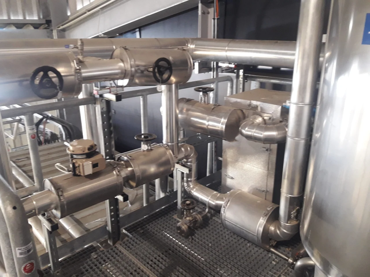 System rur ze stali nierdzewnej z zaworami i mechanizmem przepływu w przemysłowym środowisku.